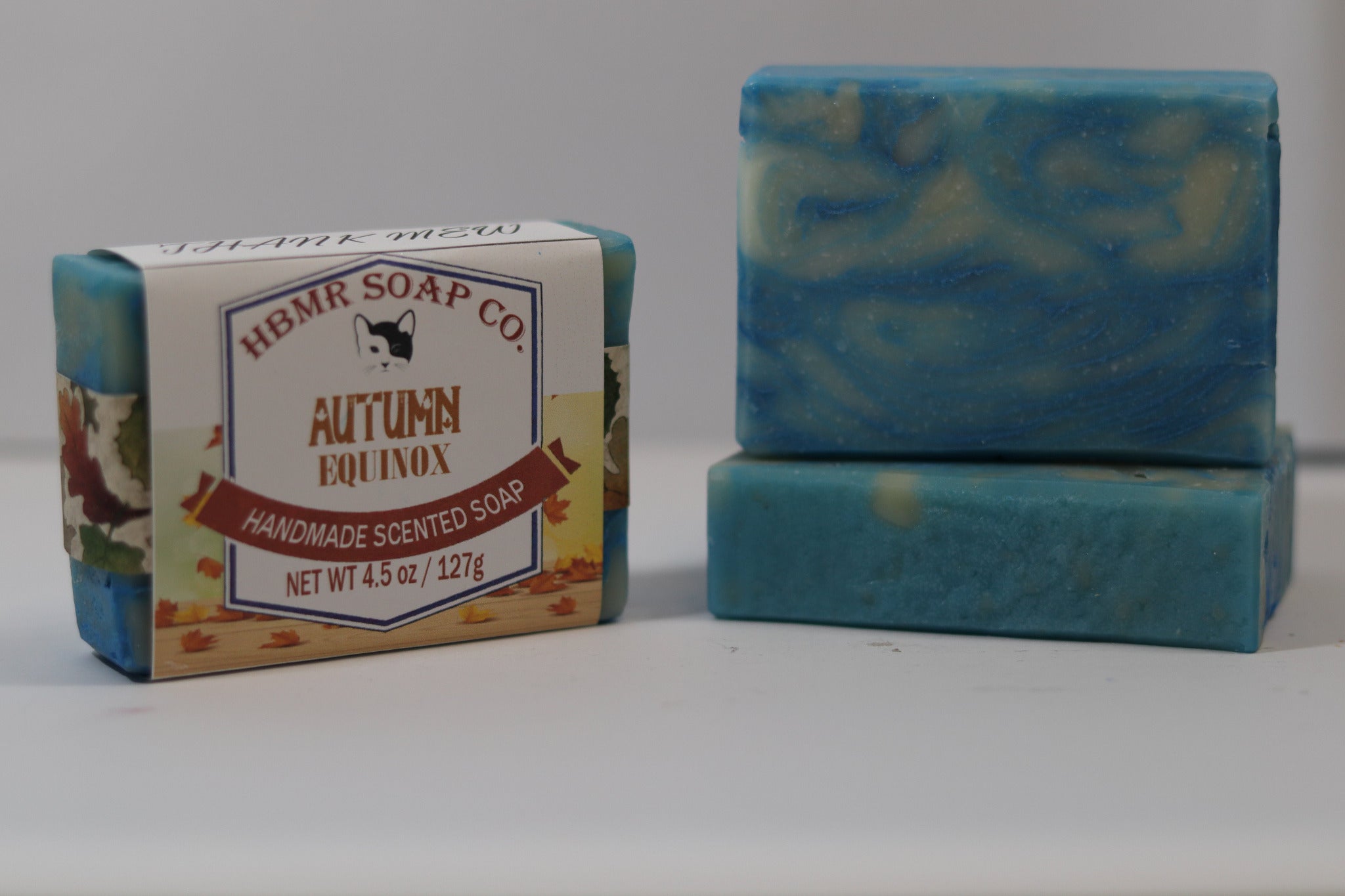 Two bars of blue soap with a box labeled 'HBMR Soap Co. Autumn Equinox' on a white background