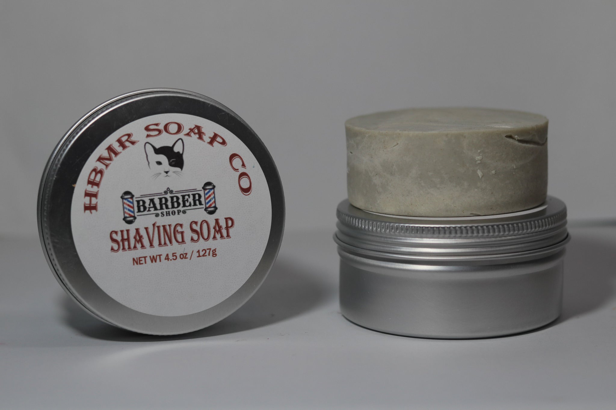 Shaving soap container with lid on a gray background