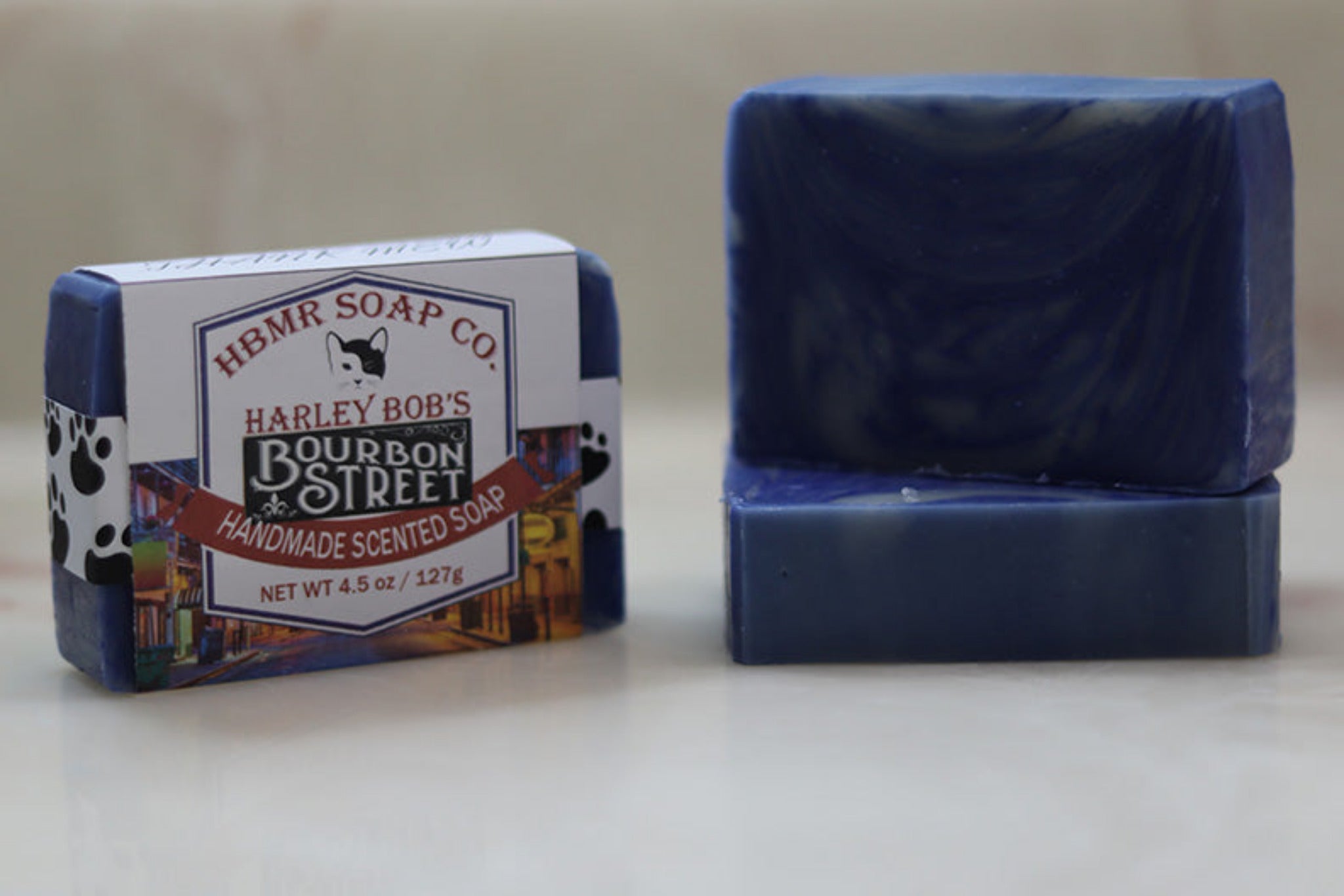 Blue soap bar and its packaging with 'Harley Bob's Bourbon Street' branding on a light background.