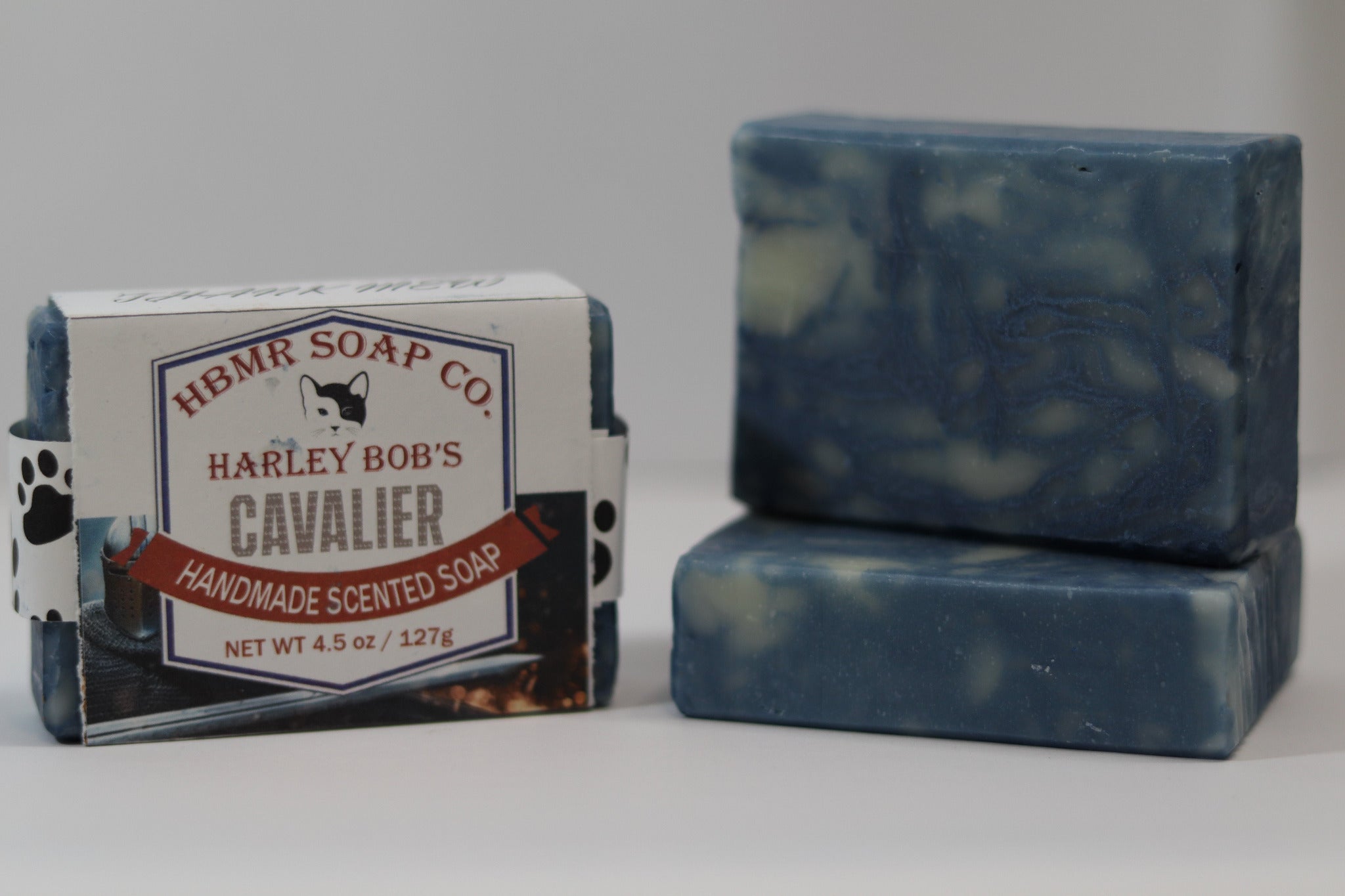 Two bars of blue soap with a packaging label for Harley Bob's Cavalier soap from HBMR Soap Co on a white background.