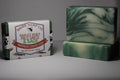 Two bars of soap, one with packaging, on a gray background