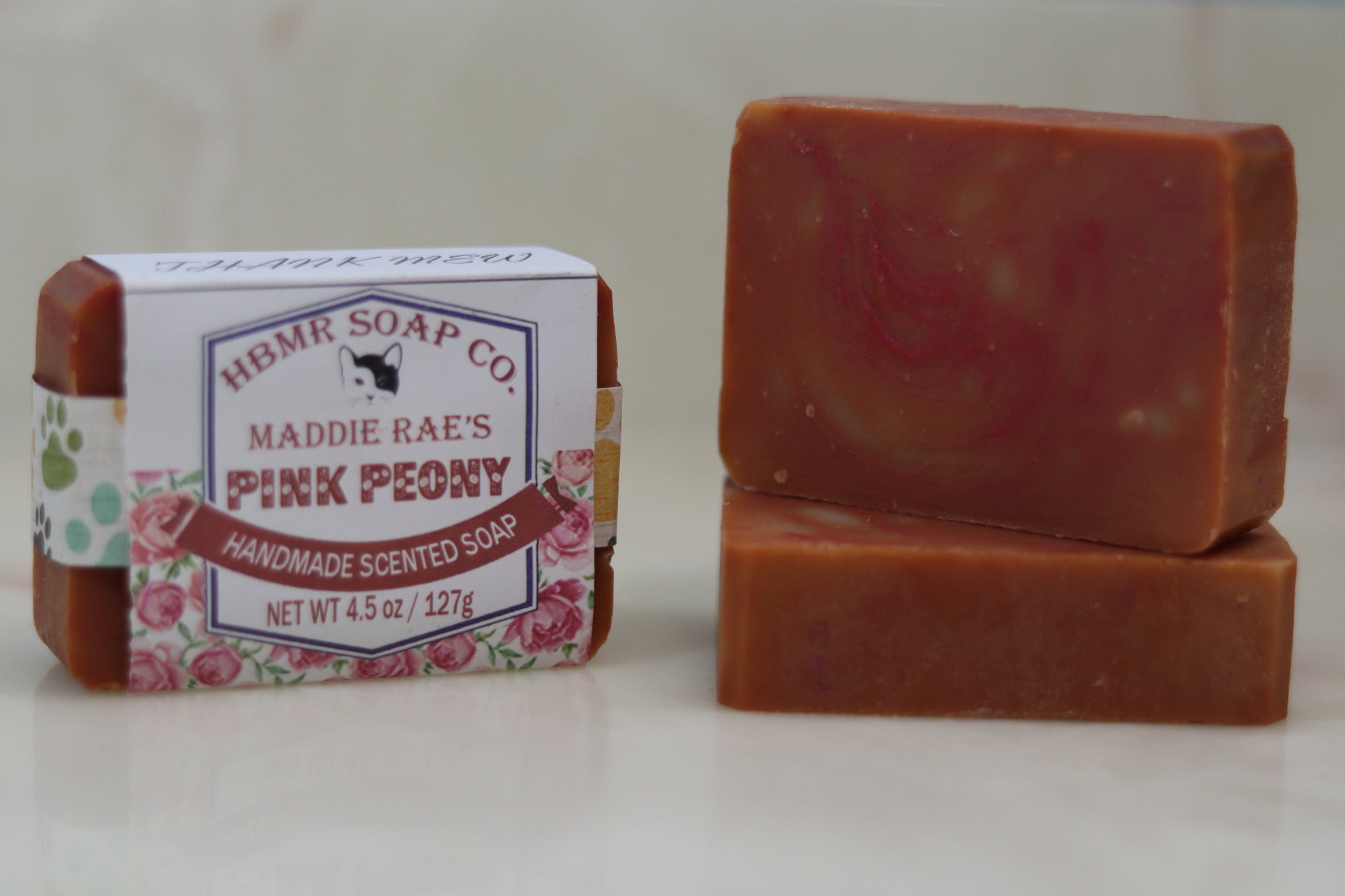 Two bars of soap, one with a label, on a white background