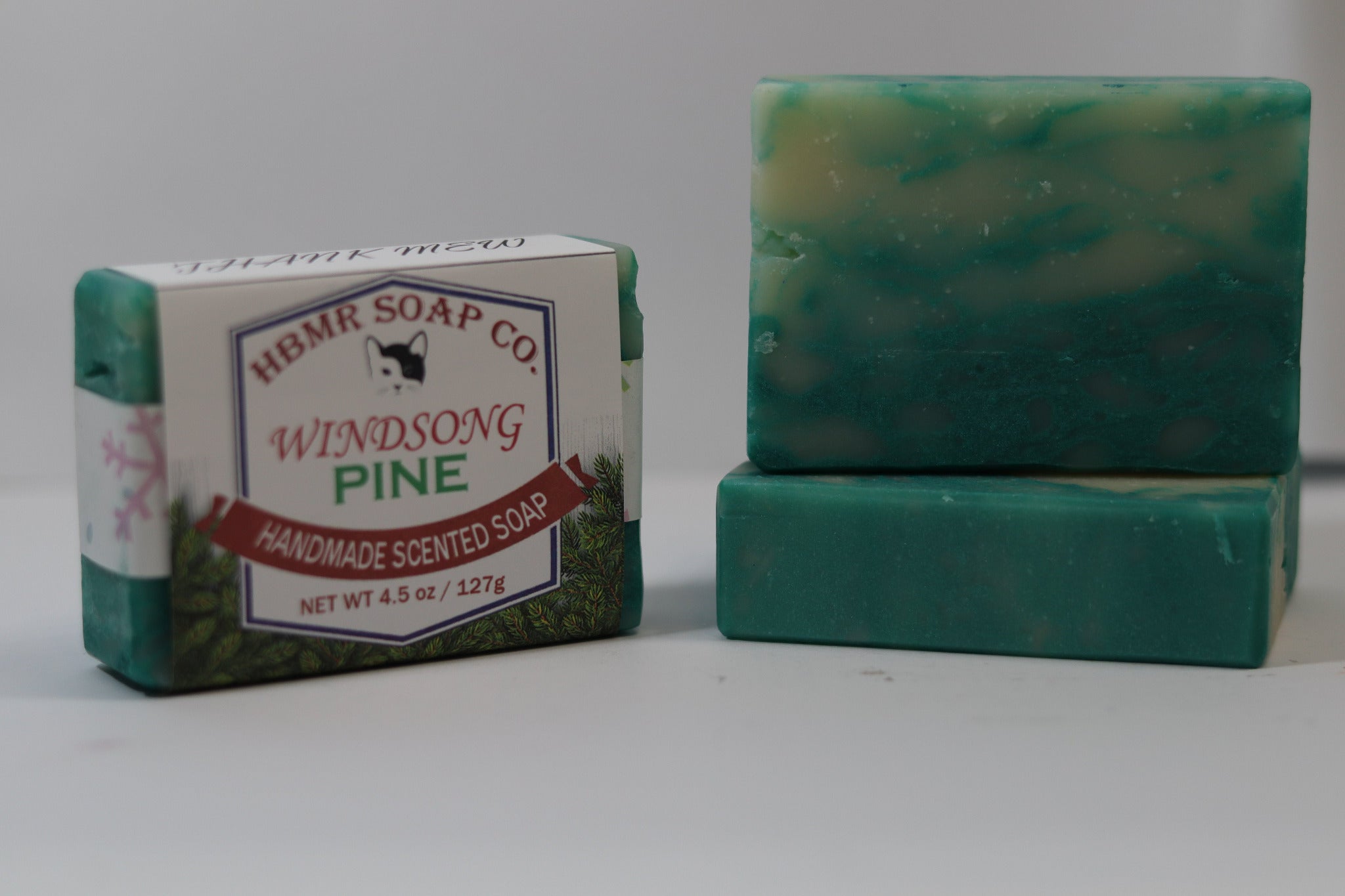 Two bars of HBMR Soap Co. Windsong Pine soap on a white background