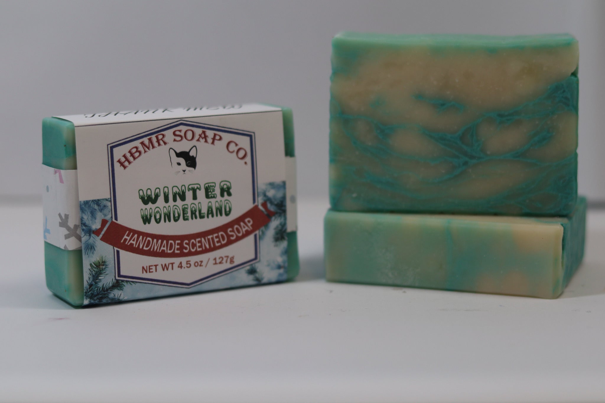 Two bars of soap, one with a label, on a plain background